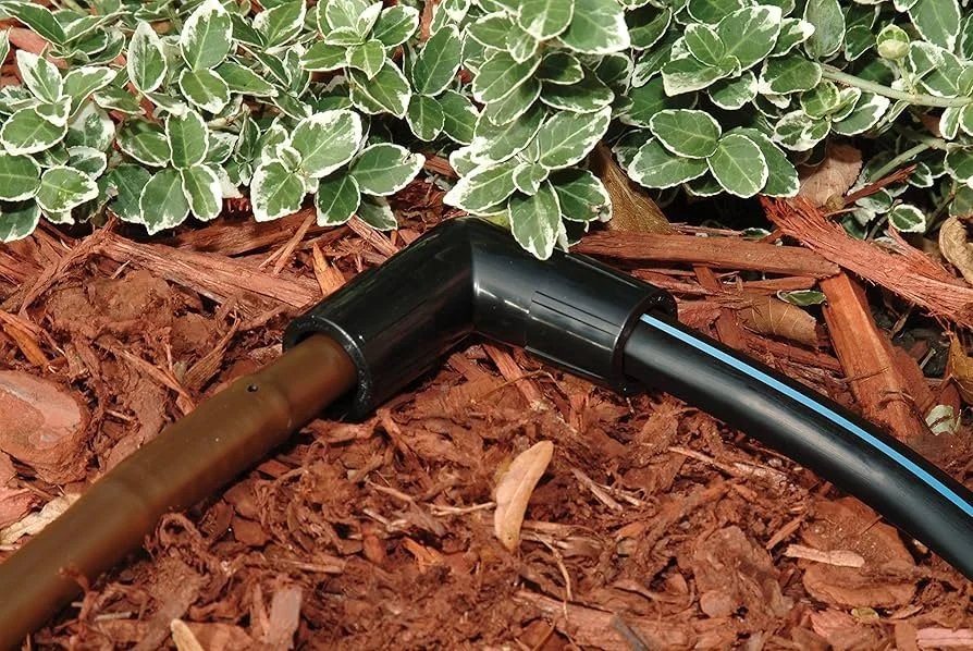 Drip irrigation line running through a mulched water-wise planting bed
